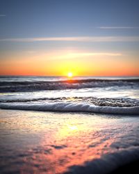 Sea waves crashing on shore in close-up during sunrise