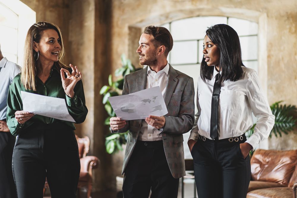 Three cheerful businessperson walking together in an office