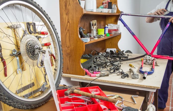 Hands of real bicycle mechanic sanding frame bike