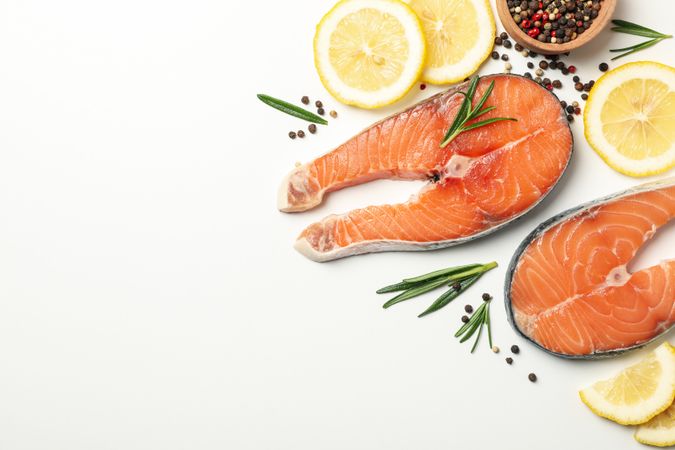 Composition with salmon meat and spices on plain background, top view