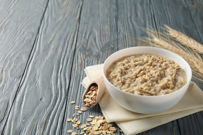 Composition with oatmeal porridge on wooden background. Cooking breakfast