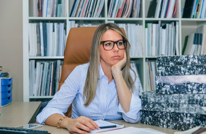 Overwhelmed woman with lots of work in office