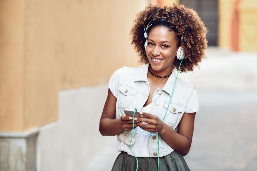 Happy woman smiling at camera while wearing headphones