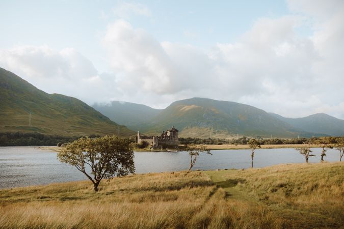 Ancient castle against hills on lake coast