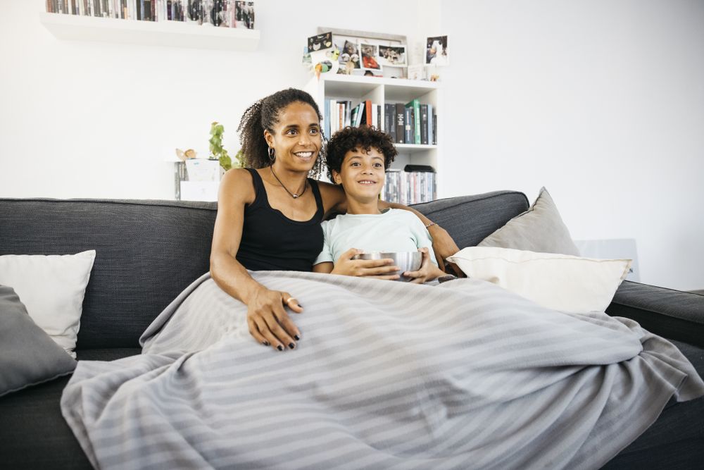 Mother and daughter watching tv at home