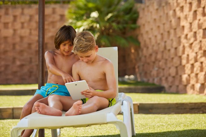 Boys using tablet in garden