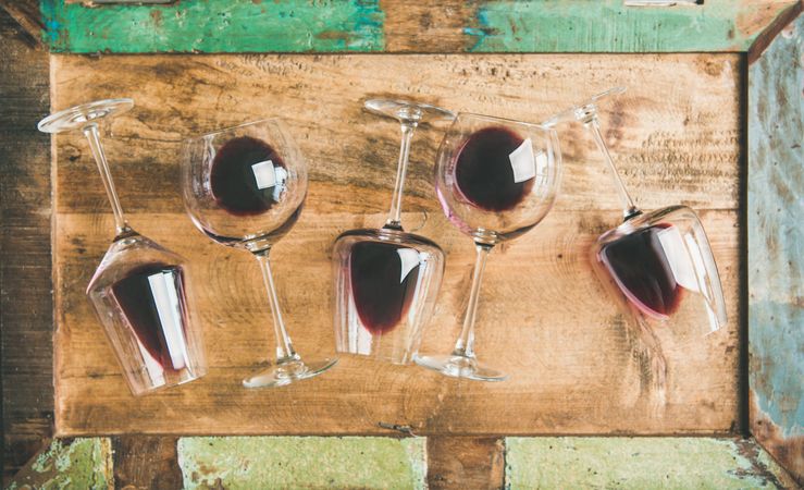 Glasses of red wine glasses scattered on wooden background