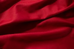 Close up crumpled wavy Red silky fabric background texture.