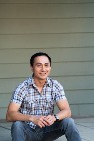 Portrait of man sitting on porch smiling and looking at camera