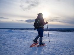 Person snowshoeing in the snow in late afternoon