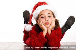 Girl in santa outfit lying on stomach on ground resting her head on her hands bGVma4