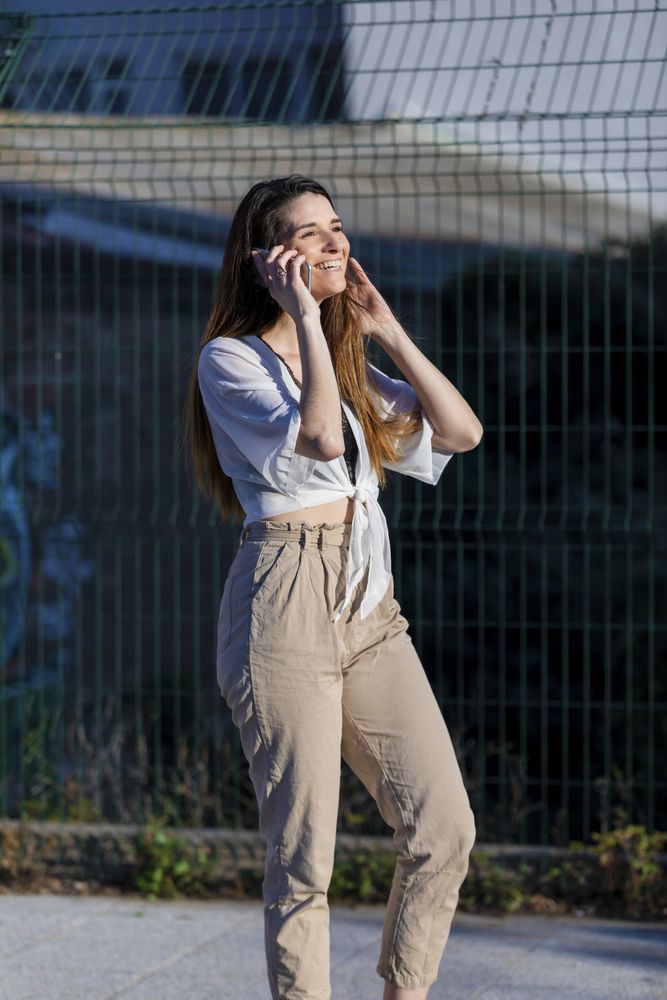 Young woman standing in the street while using a mobile phone