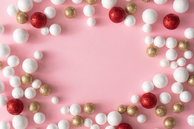 Christmas pink background with copy space made of gold, red and glitter ball decoration