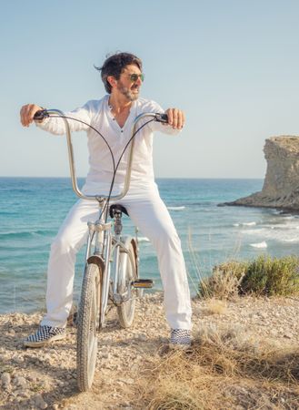 Man cycling on sandy beach hill