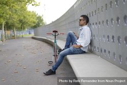 Male in sunglasses relaxing outside of park with bicycle 4dVZL0