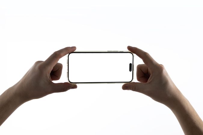 Hand holding smartphone on bright background