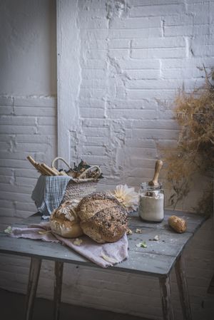 Fresh bread on served table and bunch of dry plant hanging on thread