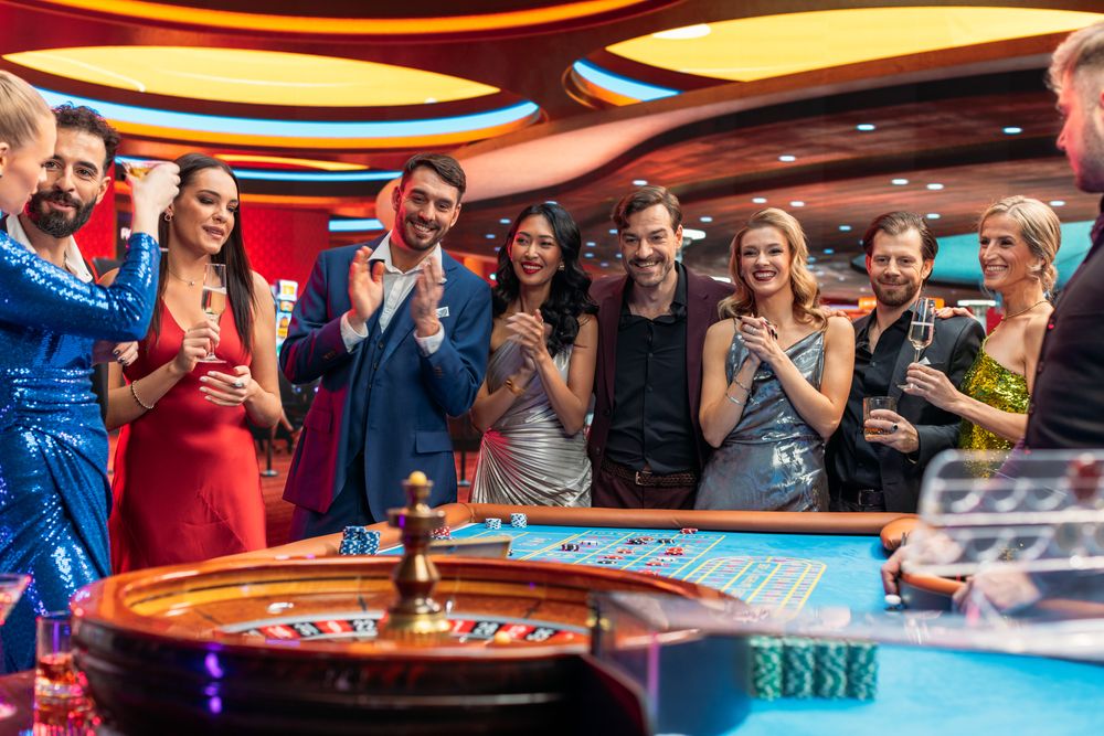 Casino Players Making Bets at a Roulette Table. Vibrant Crowd of International Young People Enjoying Nightlife in a City.