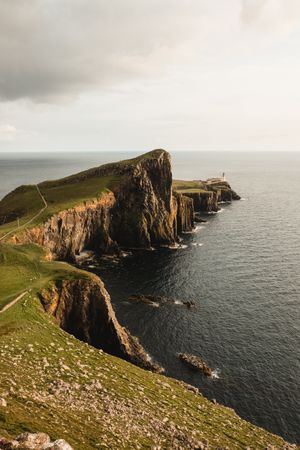 Rocky coast among tranquil ocean water in sunny day
