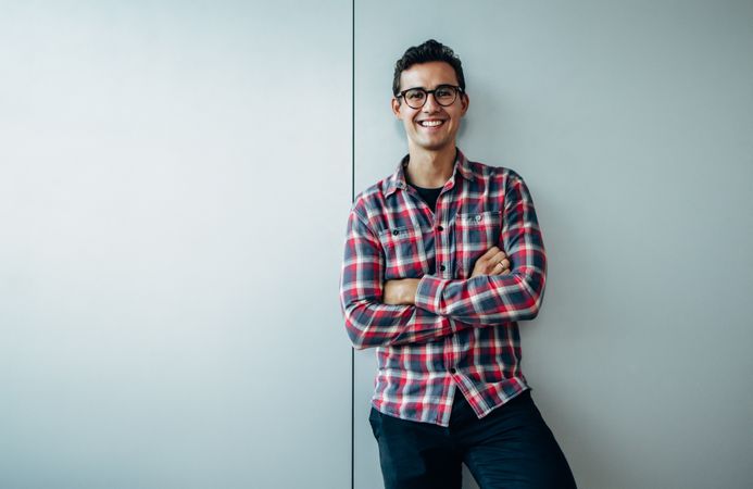 Portrait of positive young businessman dressed in plaid shirt