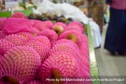Pear fruit pack wrapped in pink and for sale in grocery store 0WOPqM