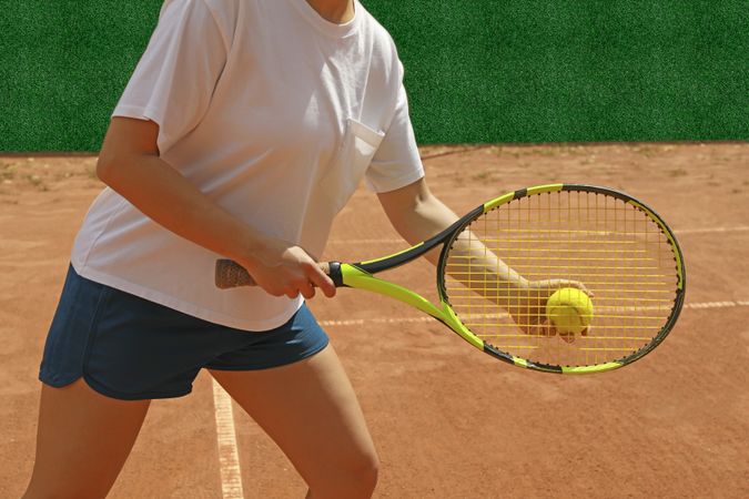 Woman hold racket and tennis ball on clay court
