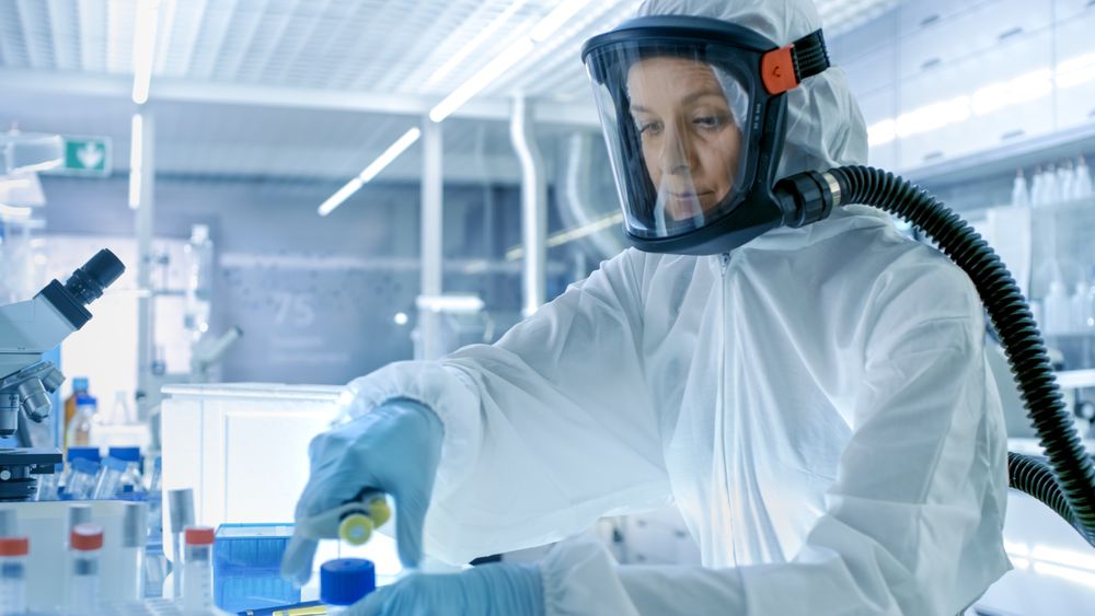 Medical Virology Research Scientist Works in a Hazmat Suit with Mask