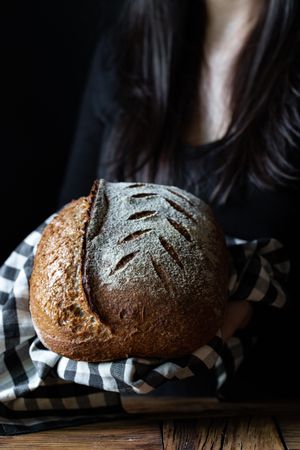 Crop person holding some bread