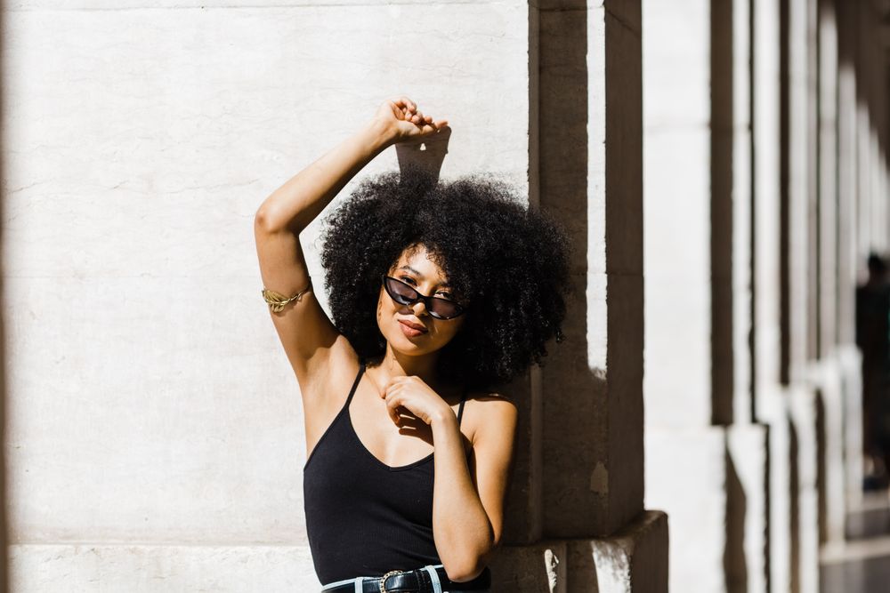 Cheerful Black female in dark sunglasses