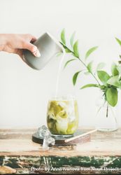 Iced matcha drink with hand pouring cream 0yjv75