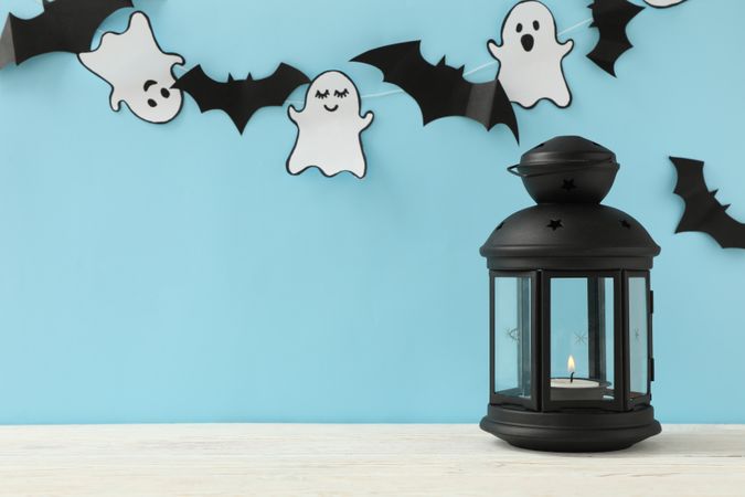 Lantern, paper ghosts and bats on blue background