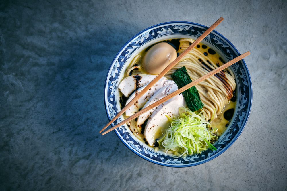 Tasty ramen with noodles and chicken fillet slices in bowl