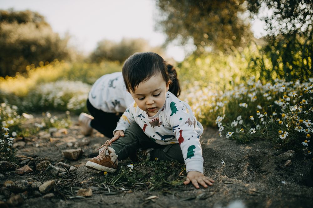 Two children playing in the dirt outside