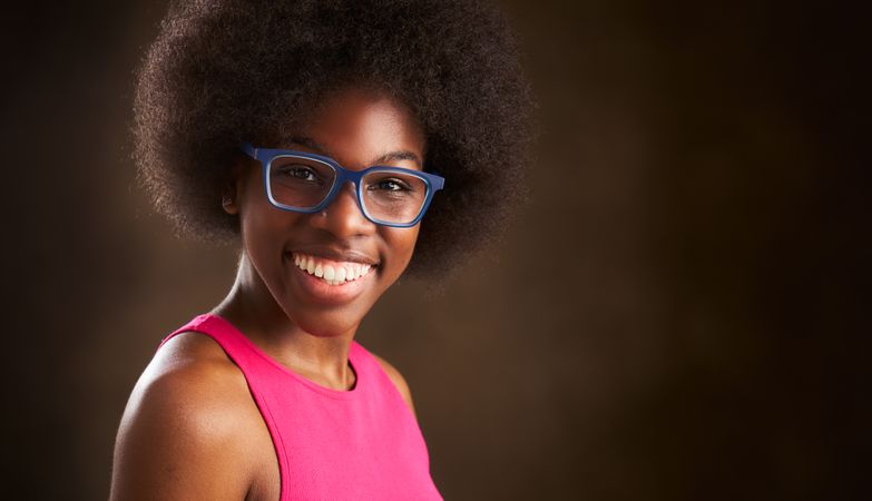young Black woman with afro hairstyle happy smiling looking at camera