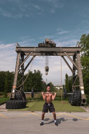 Black guy with barbell in outdoor gym
