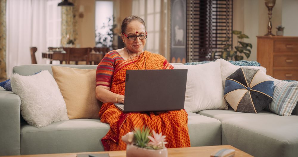Indian Mature Woman Using Laptop: Exciting Online Adventures, Broadening Horizons, Sparking Joy Through Digital Exploration.