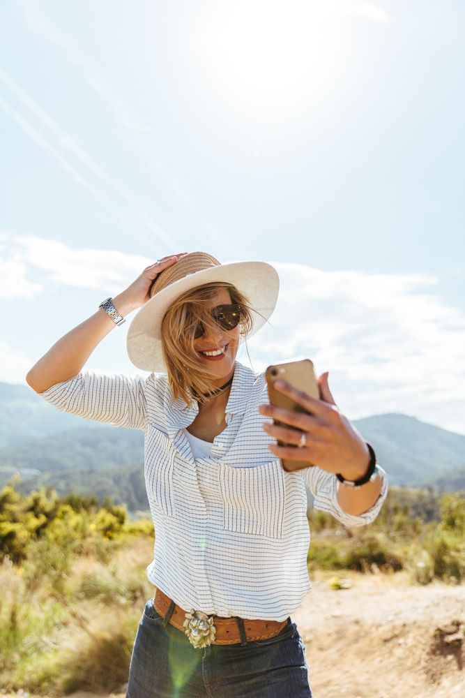 Young woman smiling while looking at her smart phone