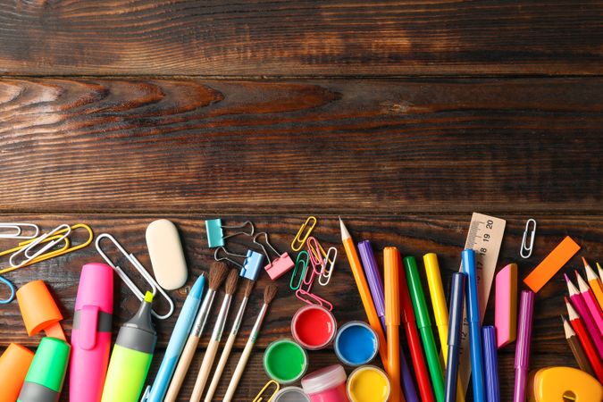 Flat lay composition with school supplies on wooden background, space for text