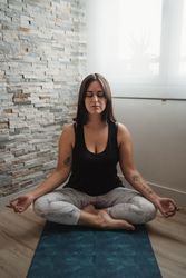 Woman in lotus pose meditating at home