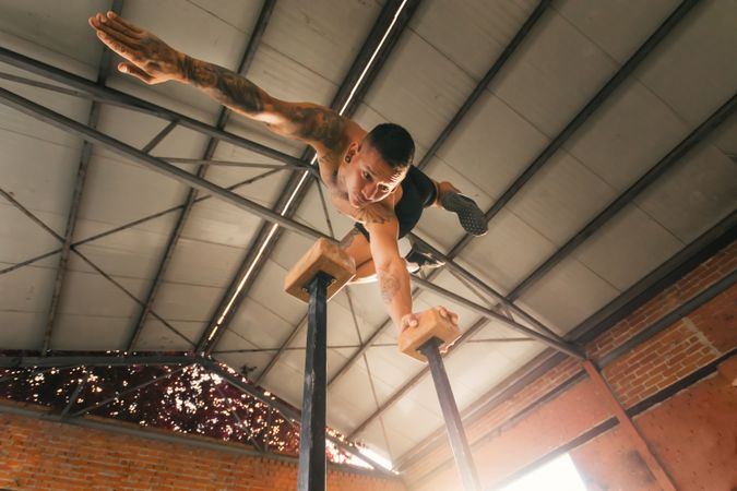 man athlete doing one hand handstand, low angle