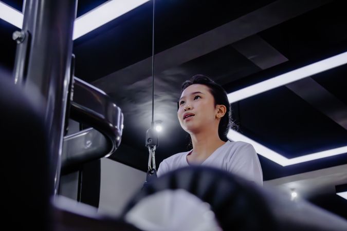 Focused woman engages in strength training exercise in modern gy