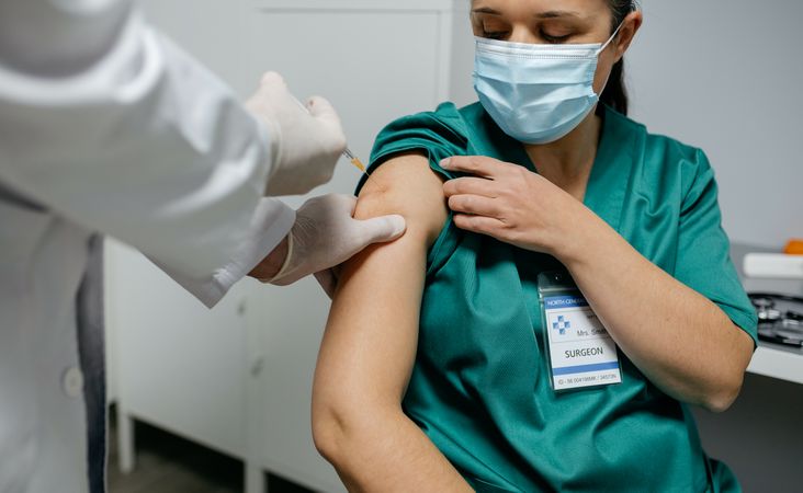 Female surgeon receiving coronavirus vaccine