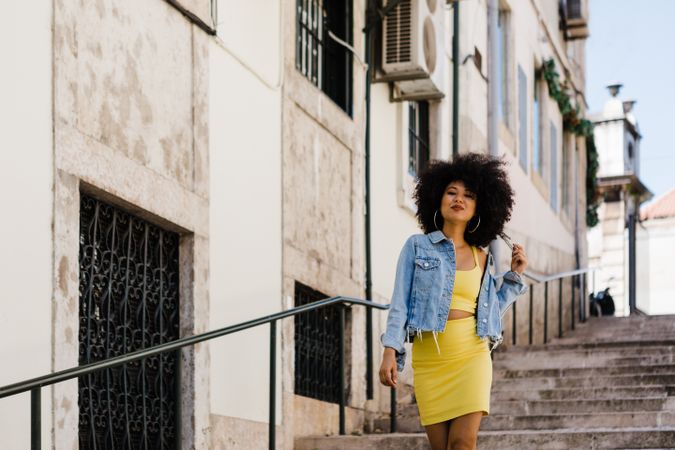 Stylish female standing on stairs with railing outdoors
