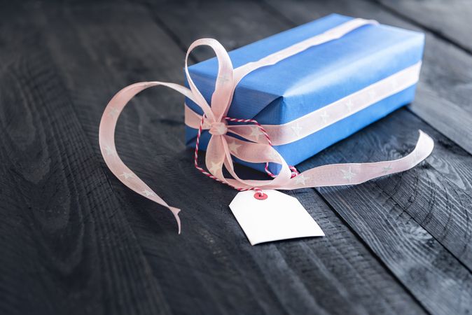Blue present with pink ribbon and blank gift tag