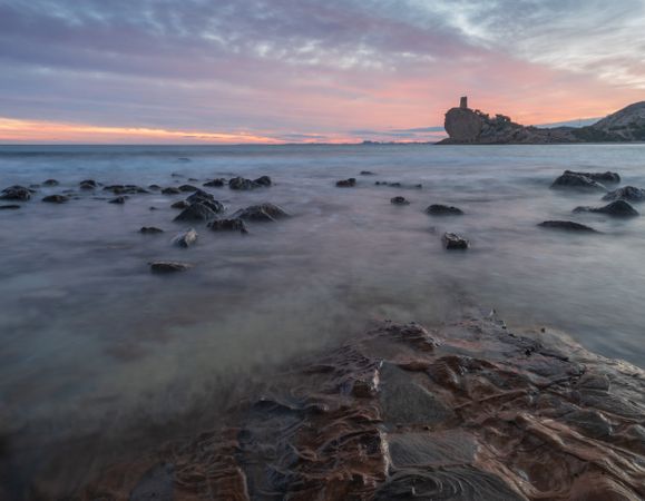 Sundown sky over sea and stony coast