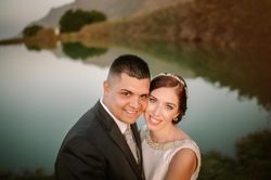 Satisfied bride and groom on background of lake surrounded by mountains