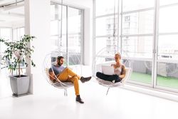 A man and woman working separately in a bright modern office