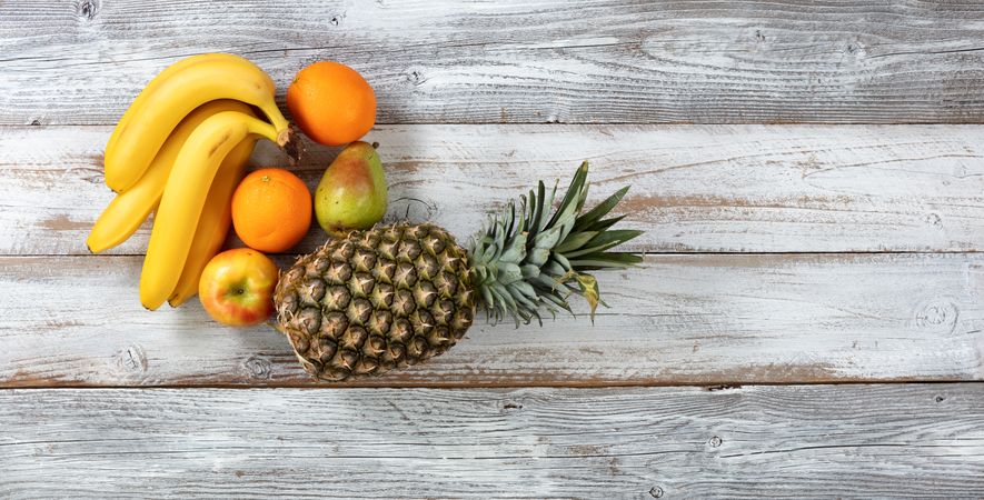 Fresh organic fruit on rustic wooden table in overhead view