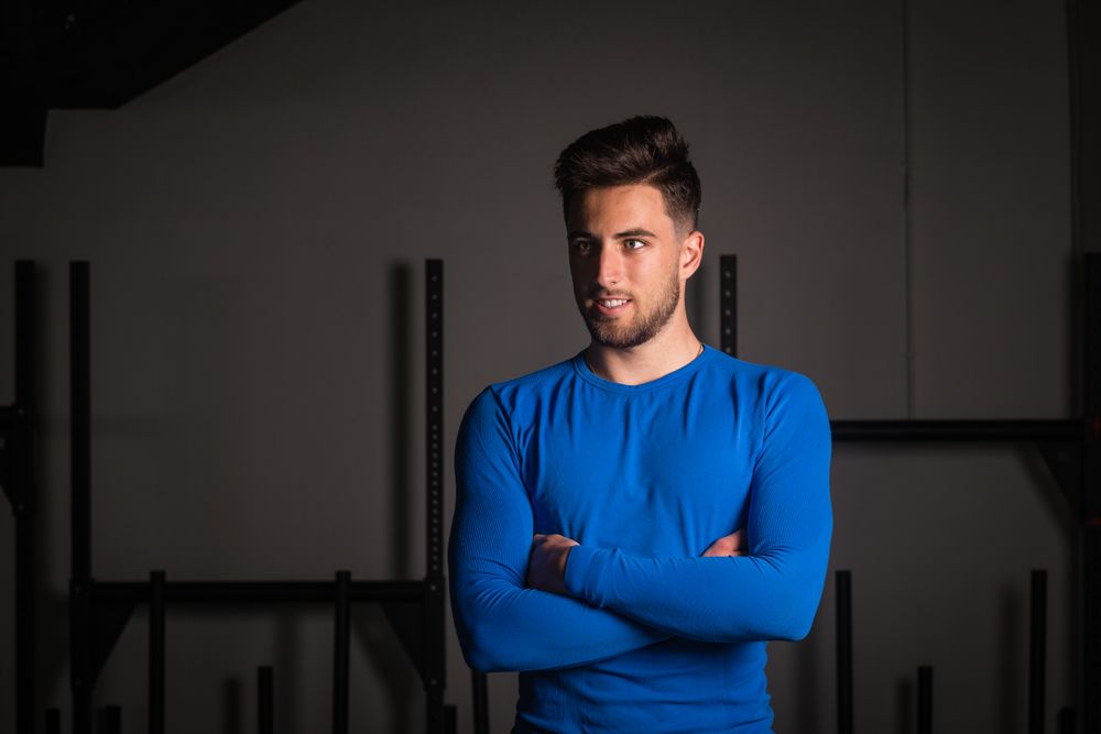Smiling man with crossed hands in gym