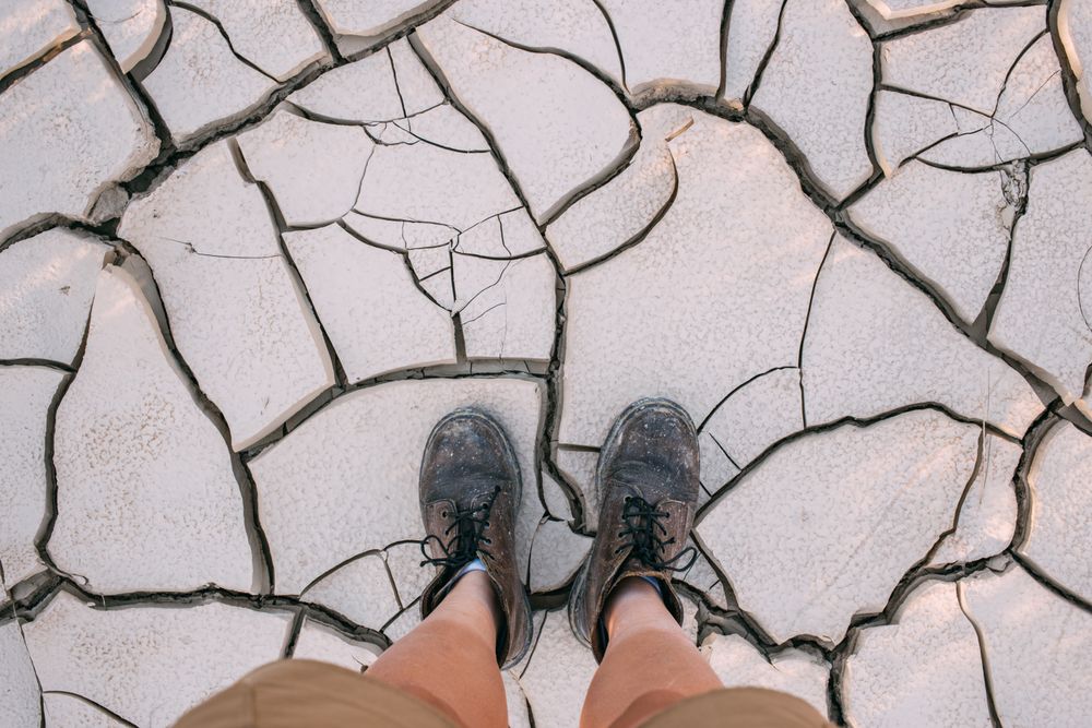 Looking down on boots on dry earth